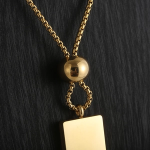 Macro view of 18K gold-plated square pendant with cylindrical box chain and slider bead