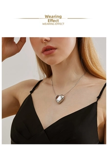 Wearing effect of a polished silver heart pendant necklace on a minimalist neck chain