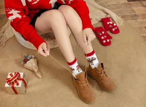 Cozy Christmas themed outfit with reindeer socks, suede boots, and warm knitted sweater