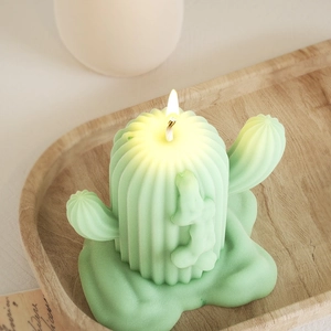 Dettaglio di candela profumata a forma di cactus verde chiaro su vassoio in legno