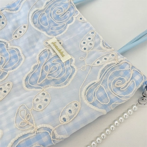 Détail du sac en toile à carreaux bleu clair avec broderie dentelle blanche et chaîne perle
