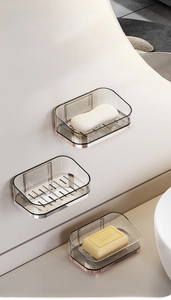 Macro detail of wall-mounted smoke grey soap holders with luxury gold finish drain bases