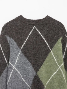 Close-up of the knitted argyle pattern and round neckline on a casual sweater