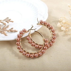 Detailed view of handmade beaded hoop earrings with natural pearls on gold stainless steel