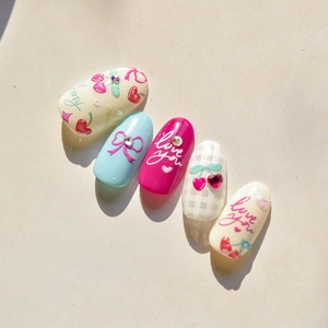 Detail of DIY nail art stickers with cherry, bow, and Love You patterns in pastel colors
