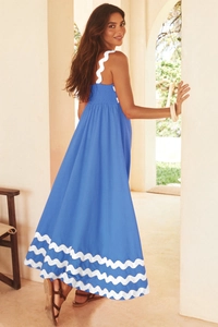 Detail view of bright blue maxi dress showing smocked back and white wavy lace trim