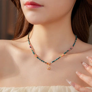 Détail du collier à pendentif soleil avec pierres colorées sur le cou d'un mannequin