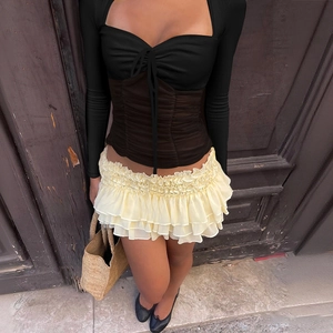 Women's long sleeve tie-front top with tiered ruffle skirt in a stylish urban outfit