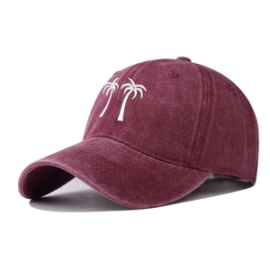 Detailed embroidery of white palm trees on a vintage washed burgundy baseball cap