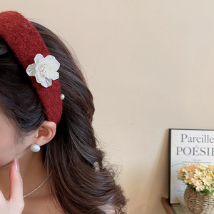 Detail of red tweed flower headband with pearls and matching jewelry on a model