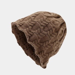 Close-up of brown cable knit beanie showing thick texture and wavy scalloped edge detail