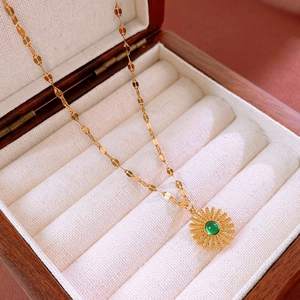 Detail of sunflower pendant necklace with green gemstone in a luxury gift box