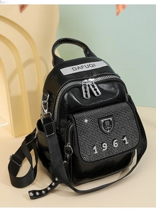 Detail shot of the rhinestone 1961 pattern and silver buckle on black leather backpack