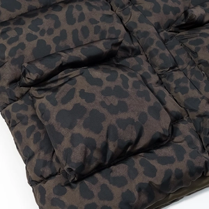 Close-up of stylish leopard print puffer jacket with textured pocket and quilted fabric