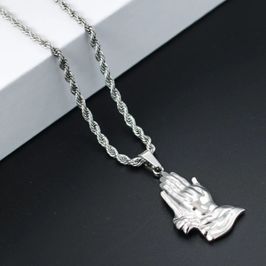 Detailed close-up of a silver-toned praying hands pendant with a twisted rope chain
