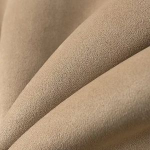 Gros plan sur la texture du tissu beige montrant une surface en daim doux et velouté
