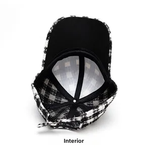 Detail view of the black and white tweed baseball cap interior with checkered lining
