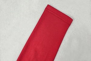 Detail view of red long sleeve dress showing high-quality double-stitch sewing on the hem