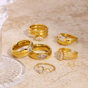Minimalistisches Gold-Ring-Set aus Edelstahl mit Zirkonia auf Steinfläche