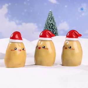 Three mini resin Christmas potato figurines with red hats on snow for festive DIY decor