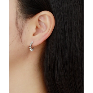 Close-up of s925 silver C-shaped hoop earrings with pearls on a model wearing them