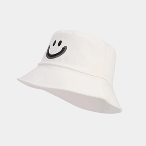 Close-up of white cotton bucket hat with black smiley face print for sun protection