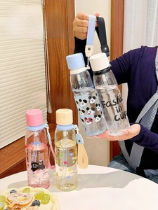 Detail of portable plastic straw water bottles with colorful cartoon dog patterns and straps