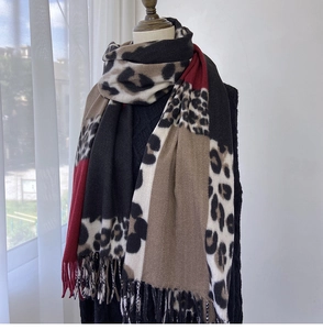 Detail of leopard print patchwork scarf with burgundy and camel blocks and tassel fringe