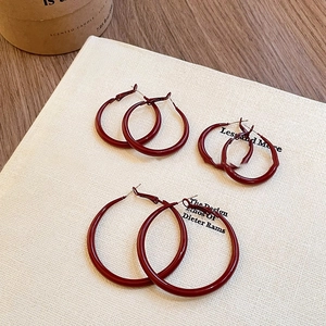 Three pairs of glossy red geometric hoop earrings in small, medium and large sizes