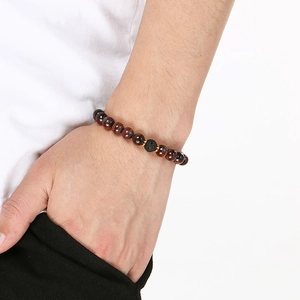 Elastic beaded bracelet with red tiger eye stone, lava bead and golden spacers on wrist