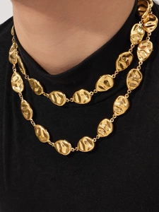 Close-up of dual 18k gold-plated chunky link necklaces on a model with a dark backdrop