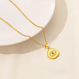 Detailed close-up of golden evil eye pendant necklace with a blue zircon stone