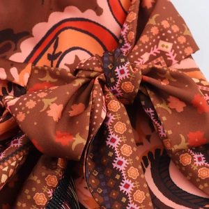 Ethnic knot mini skirt with paisley patterns and decorative tassel bow details