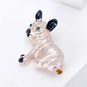 Detail of enamel bulldog brooch with green gem eyes and polished golden pin back