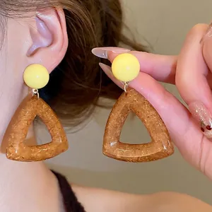Minimalist resin earrings with round yellow studs and amber triangular glitter pendants