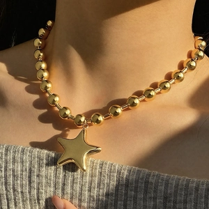 Golden beaded necklace with large star pendant shown on model for a hip-hop fashion look