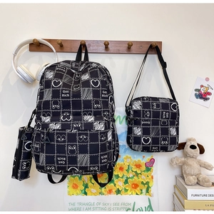 Three-piece black grid backpack set including crossbody and pouch on wooden hanger