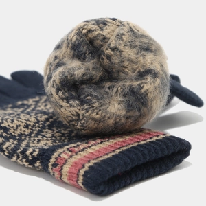 Détail macro de la maille jacquard bleu marine du bonnet et des gants d'hiver rayés