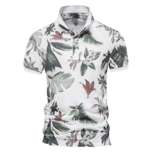 Detail of white men's polo shirt featuring tropical green leaf print and pique fabric