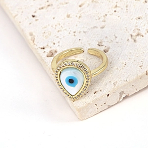 Detail view of adjustable gold evil eye ring with blue zircon stones on stone base