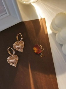 Dettaglio orecchini a cuore vintage in argento S925 con finitura dorata testurizzata