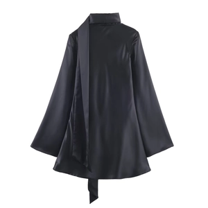 Detail view of a black satin dress with long sleeves and elegant neck scarf ties