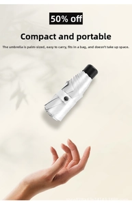 Compact five-fold silver travel umbrella shown held in palm for portable size detail
