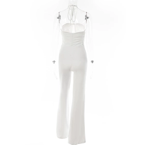 Detail view of the back of a white halter jumpsuit with ruched fabric and flared leg design