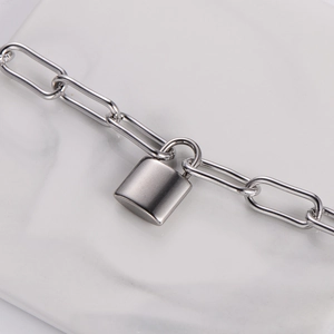 Close-up of silver paperclip chain necklace with a matte finish heart padlock pendant