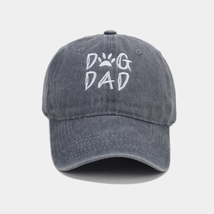 Close-up of grey washed cotton baseball cap featuring white DOG DAD embroidery with paw print