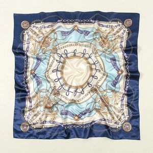Detail of silk-like square scarf featuring vintage golden chain and buckle print design