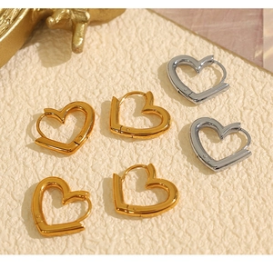 Close-up of minimalist heart-shaped hoop earrings in polished gold and silver finishes