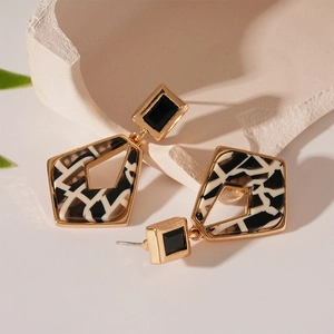 Macro shot of vintage geometric resin earrings with black diamond and marbled pattern