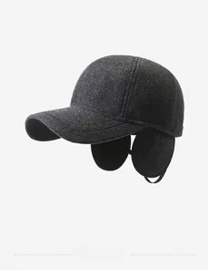 Close-up of deep gray knit texture and metal Sports label on winter earmuff baseball cap